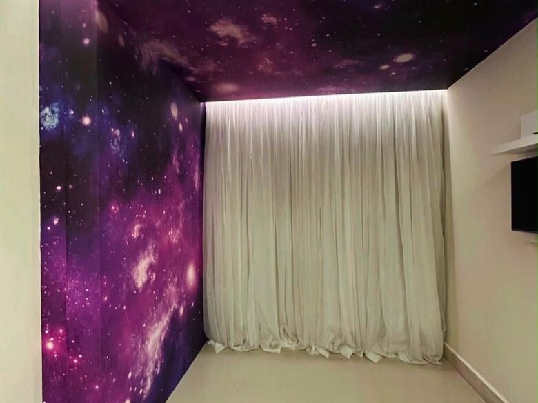 Quarto com papel de parede de galáxia na parede e no teto